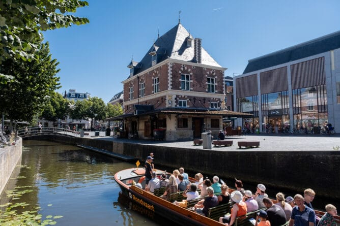 Groep toeristen maakt een vaartocht in een praam door de binnenstad van Leeuwarden